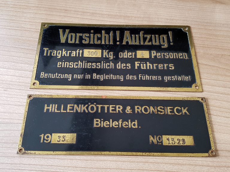 Zwei Aufzugsschilder aus dem Jahre 1933